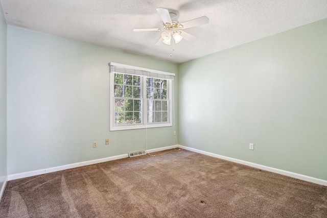 carpeted empty room with a textured ceiling, ceiling fan, visible vents, and baseboards