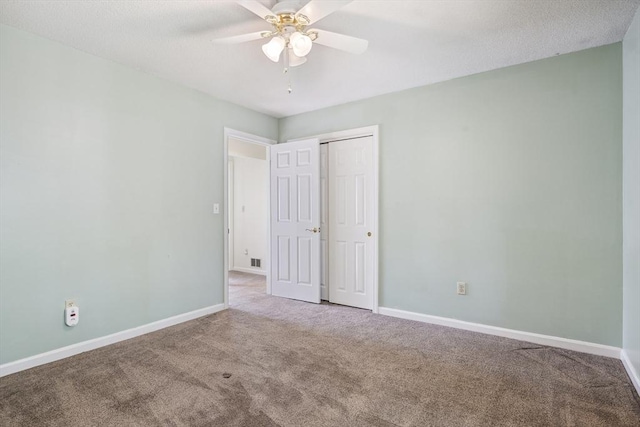 unfurnished bedroom with carpet flooring, a ceiling fan, baseboards, and a closet