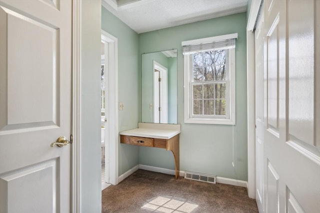 doorway with visible vents, carpet, and baseboards