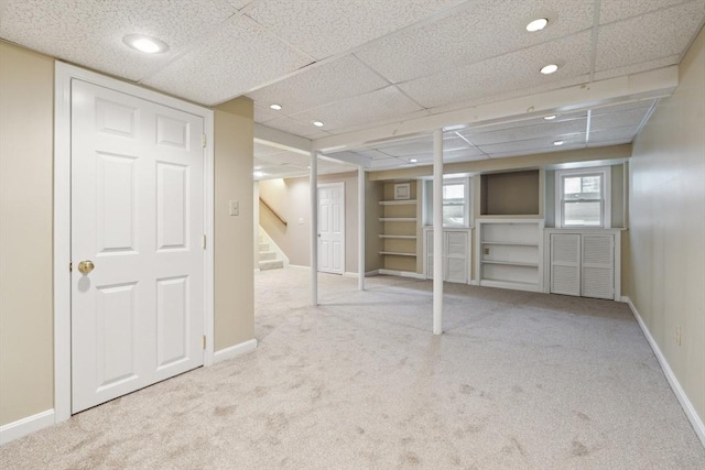 below grade area with baseboards, carpet, and stairs