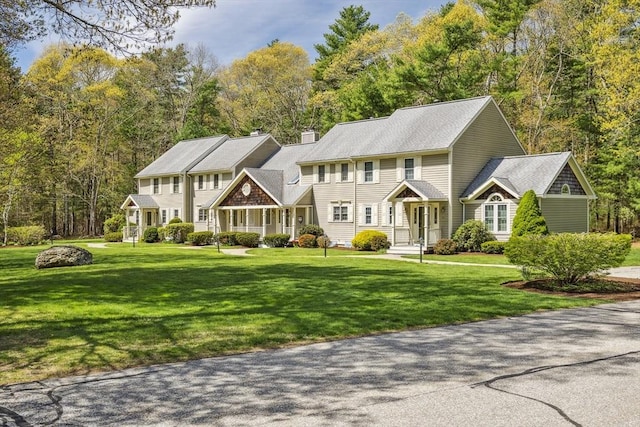 colonial home featuring a chimney and a front lawn