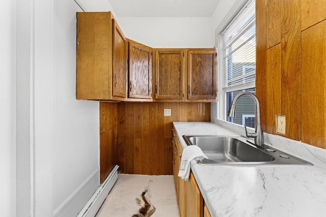 clothes washing area with baseboard heating and sink