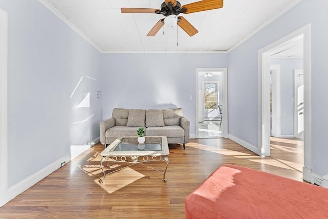 living room featuring hardwood / wood-style floors, ceiling fan, and ornamental molding