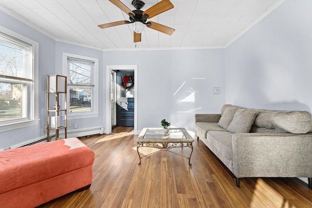 living room featuring a wealth of natural light, hardwood / wood-style flooring, baseboard heating, and ceiling fan