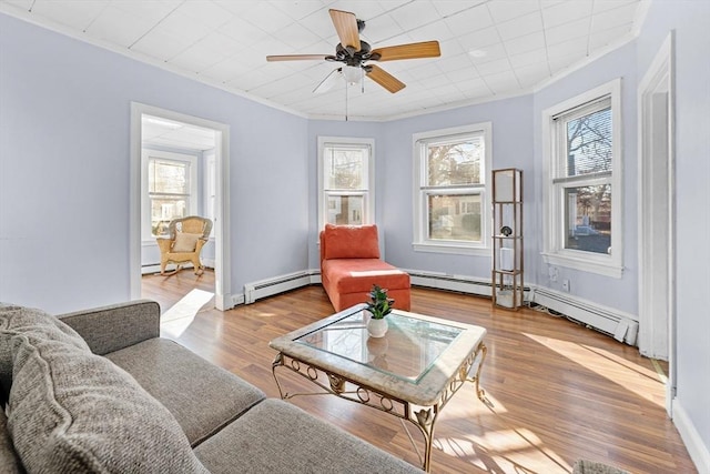 living area featuring light wood-type flooring, a baseboard radiator, ceiling fan, and ornamental molding