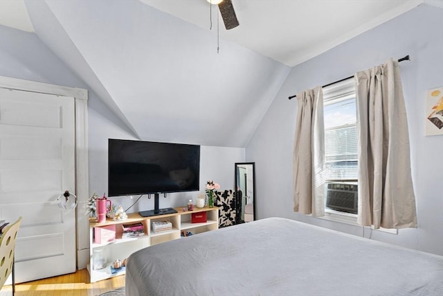 bedroom featuring ceiling fan, cooling unit, light wood-type flooring, and vaulted ceiling