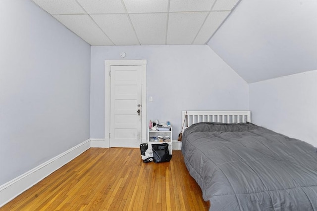 bedroom featuring a drop ceiling and hardwood / wood-style flooring