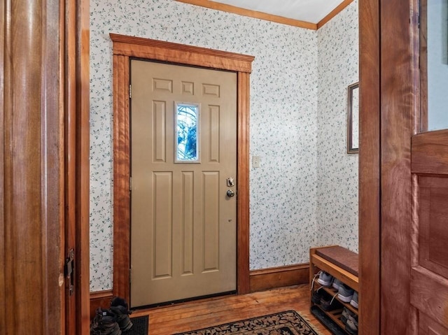 entryway with wood finished floors and wallpapered walls