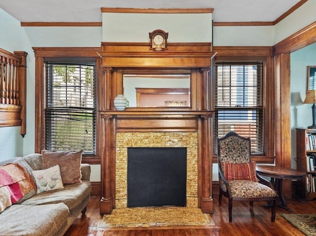 living area with crown molding, a fireplace, and wood-type flooring