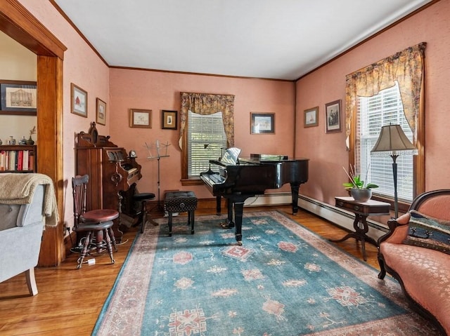 sitting room with ornamental molding and wood finished floors