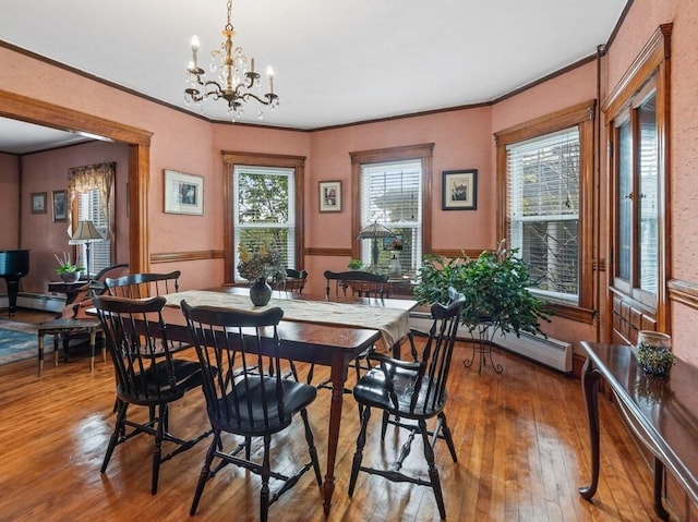 dining room with a baseboard radiator, a notable chandelier, hardwood / wood-style floors, and ornamental molding