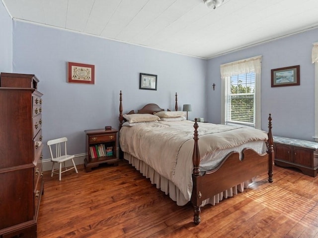 bedroom with hardwood / wood-style floors and baseboards