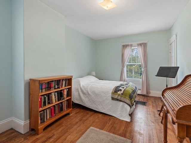 bedroom with baseboards and wood-type flooring