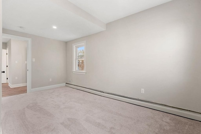 empty room featuring light colored carpet and baseboard heating