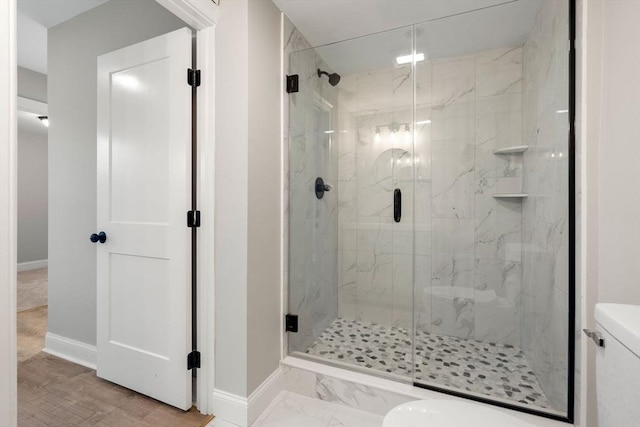 bathroom with a shower with door and toilet