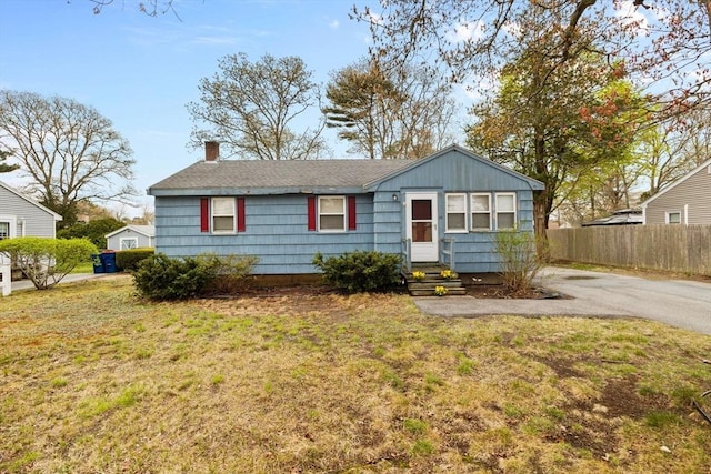 view of front of property with a front lawn, fence, and a chimney