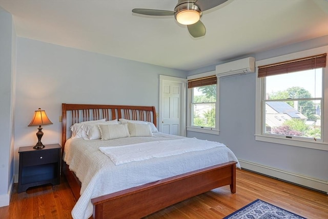 21 Mechanic St, Holliston, MA 01746 - bedroom featuring a wall mounted AC, baseboard heating, wood finished floors, and a ceiling fan