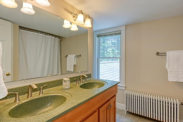 21 Mechanic St, Holliston, MA 01746 - bathroom featuring radiator heating unit, double vanity, baseboards, and tile patterned floors