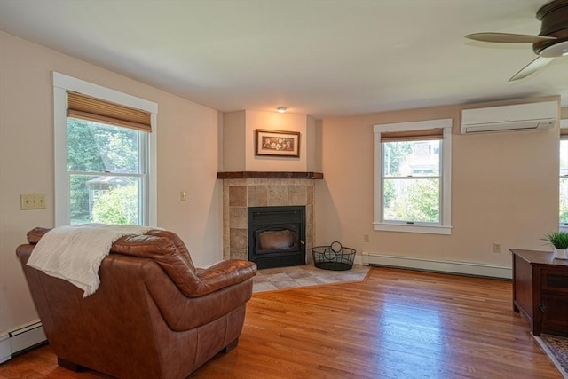 21 Mechanic St, Holliston, MA 01746 - living room with a baseboard radiator, a baseboard heating unit, a wall unit AC, wood finished floors, and a ceiling fan