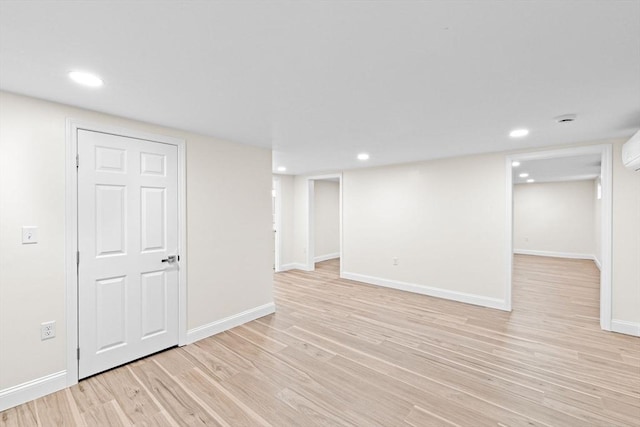 69 Wood St, Hanson, MA 02341 - finished below grade area featuring light wood-type flooring, recessed lighting, and a wall unit AC