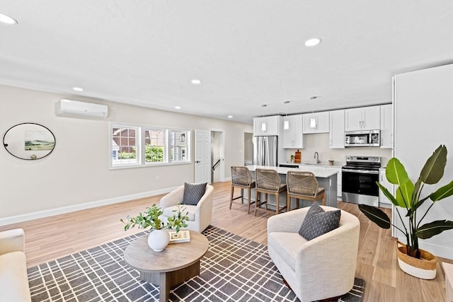 69 Wood St, Hanson, MA 02341 - living area with a wall unit AC, light wood-style floors, and recessed lighting