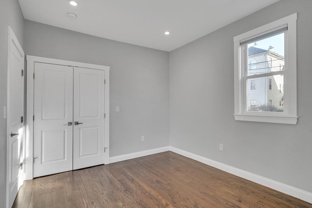 unfurnished bedroom featuring a closet and wood-type flooring