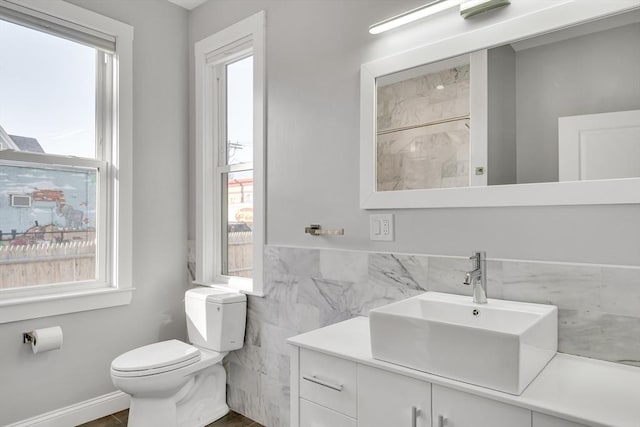 bathroom featuring toilet, vanity, and tile walls