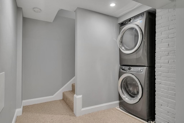 washroom with stacked washer and dryer and carpet flooring