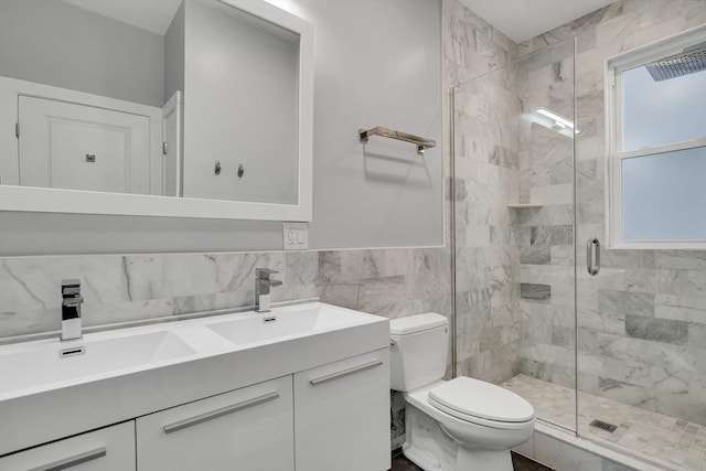 bathroom featuring a shower with shower door, tile walls, toilet, and vanity