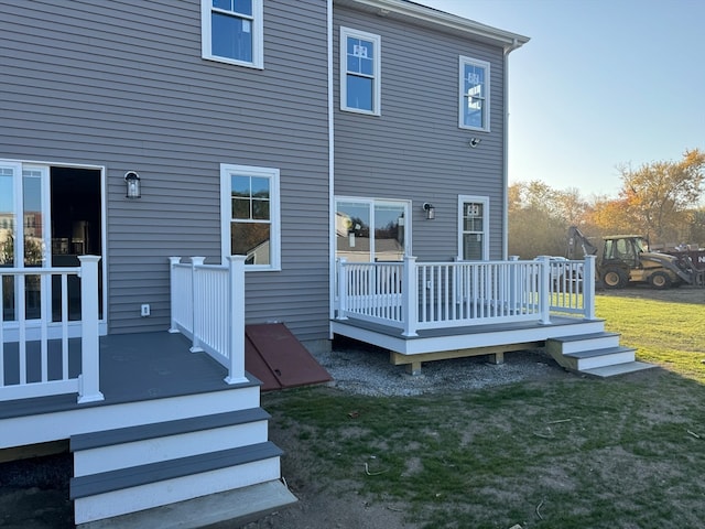 rear view of property featuring a wooden deck and a yard