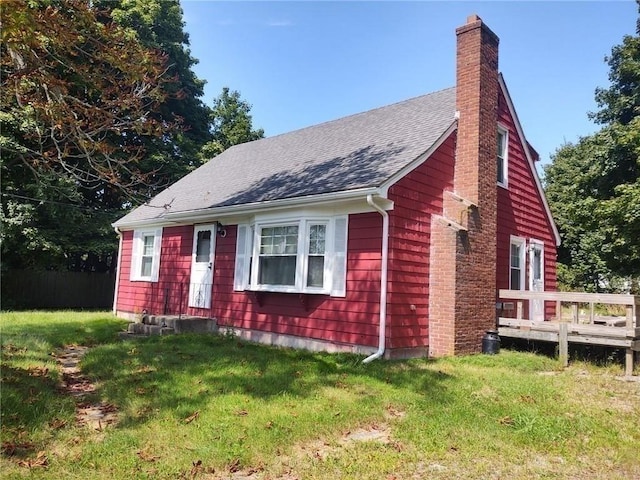 view of front facade featuring a deck and a front lawn