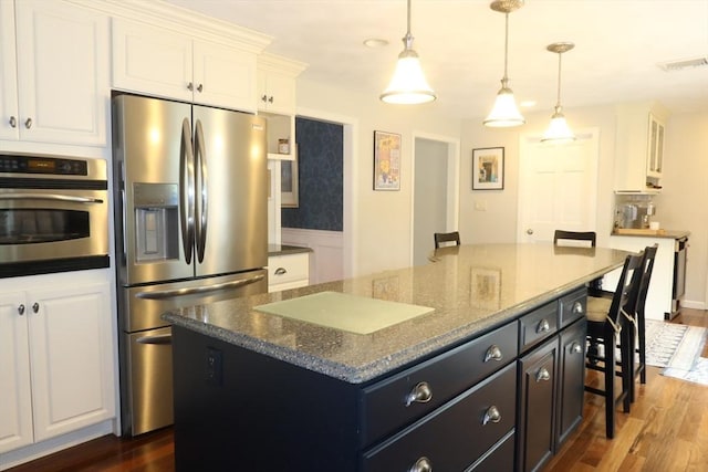 12 Hampton Ct, Walpole, MA 02032 - kitchen featuring appliances with stainless steel finishes, white cabinets, a kitchen breakfast bar, a center island, and dark wood-type flooring