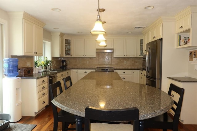 12 Hampton Ct, Walpole, MA 02032 - kitchen featuring freestanding refrigerator, under cabinet range hood, a center island, dark wood-type flooring, and decorative backsplash
