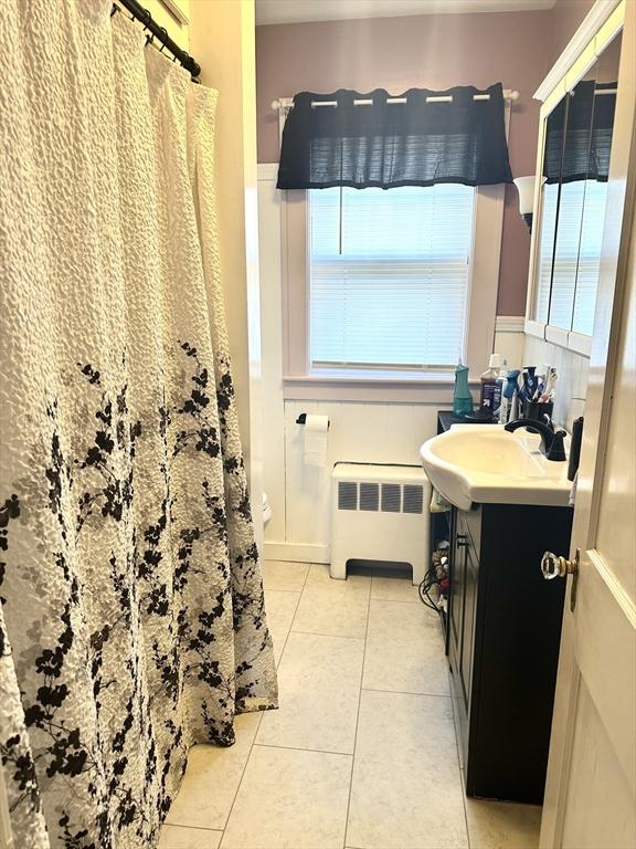 bathroom with a shower with curtain, vanity, radiator heating unit, and tile patterned floors