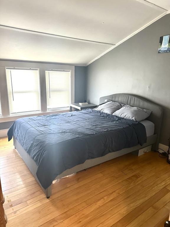 bedroom with light wood finished floors and crown molding