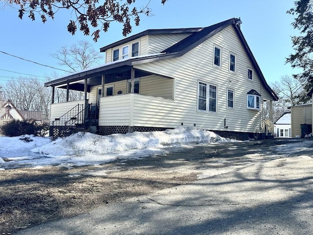 view of snowy exterior with covered porch