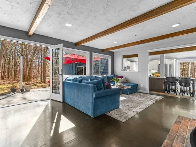 living room with hardwood / wood-style flooring, beamed ceiling, and a textured ceiling