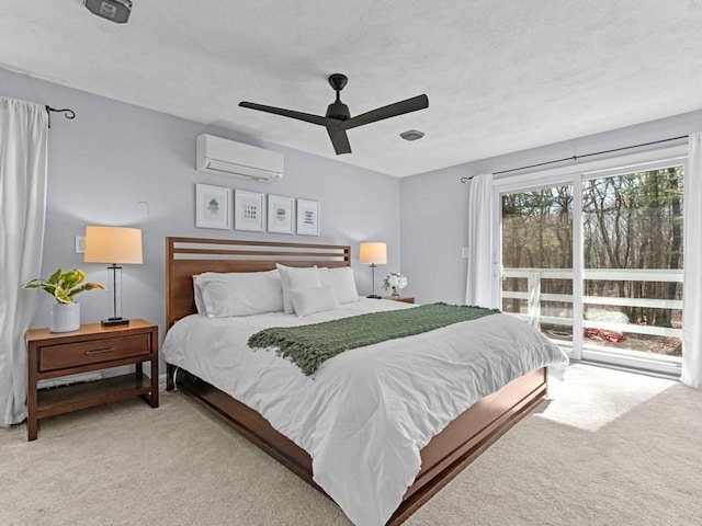 bedroom featuring light colored carpet, an AC wall unit, a ceiling fan, and a textured ceiling