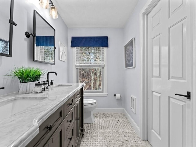 bathroom featuring visible vents, baseboards, toilet, and vanity