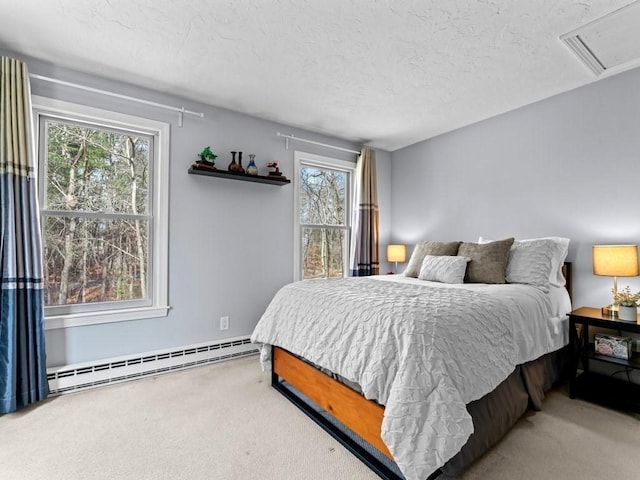 bedroom with a textured ceiling, visible vents, baseboard heating, and carpet