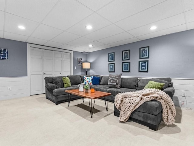 living room with recessed lighting, wainscoting, carpet, and a drop ceiling