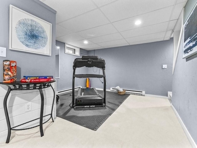 workout area featuring a baseboard heating unit, a drop ceiling, baseboards, and carpet floors