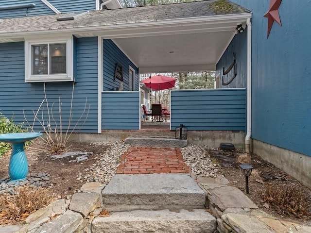 property entrance with a shingled roof