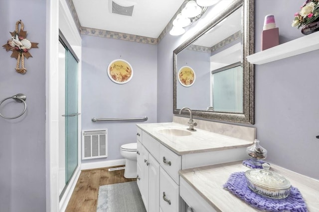 bathroom featuring a stall shower, visible vents, wood finished floors, and vanity