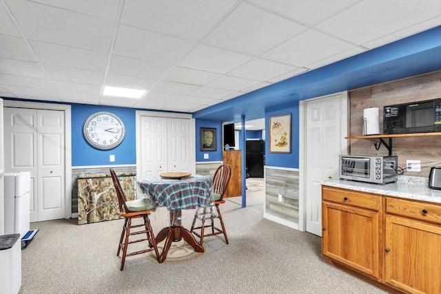 dining area featuring a paneled ceiling, a toaster, and light colored carpet