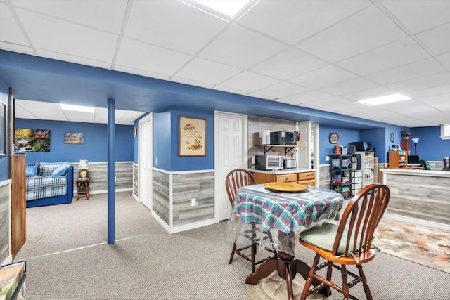 carpeted dining space with a drop ceiling