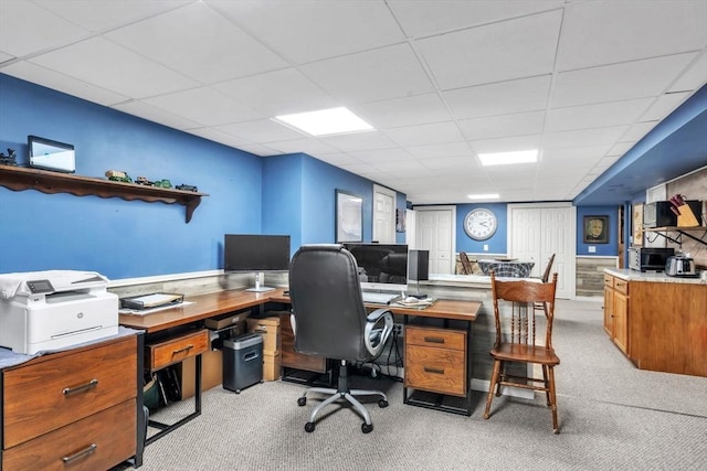 office space with a paneled ceiling and light colored carpet