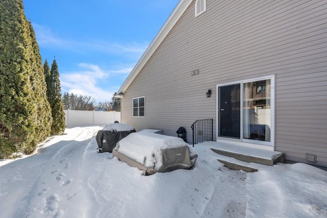 snow covered patio with fence and grilling area