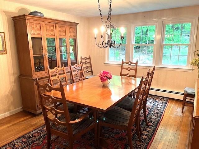 26 N Hill Rd, Westford, MA 01886 - dining room with light wood finished floors, a chandelier, baseboards, and a baseboard heating unit