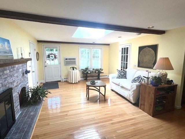 26 N Hill Rd, Westford, MA 01886 - living area with beamed ceiling, wood-type flooring, a fireplace, a wall unit AC, and a skylight
